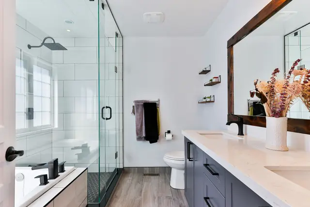 Bany modern amb dutxa de vidre i moble de lavabo fosc